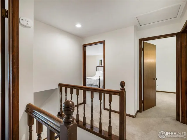 a view of a hallway with wooden floor and a bathroom