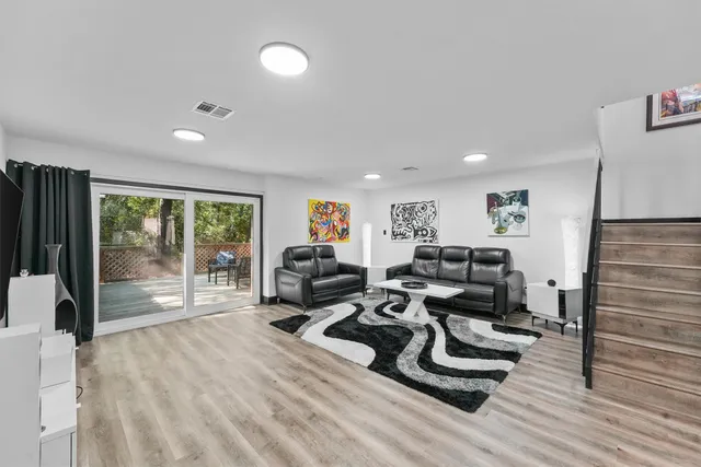 a living room with furniture and a wooden floor