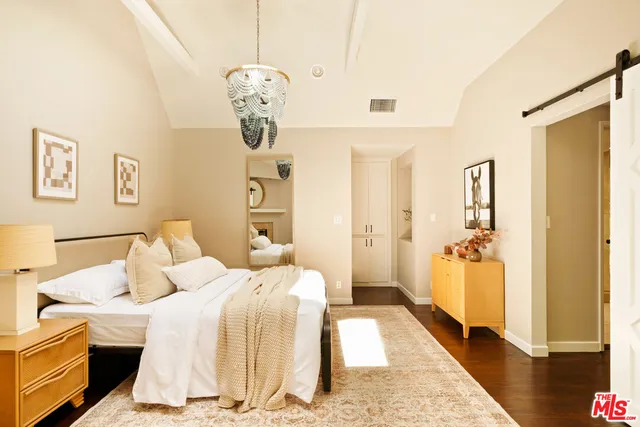 a bedroom with a bed and a chandelier