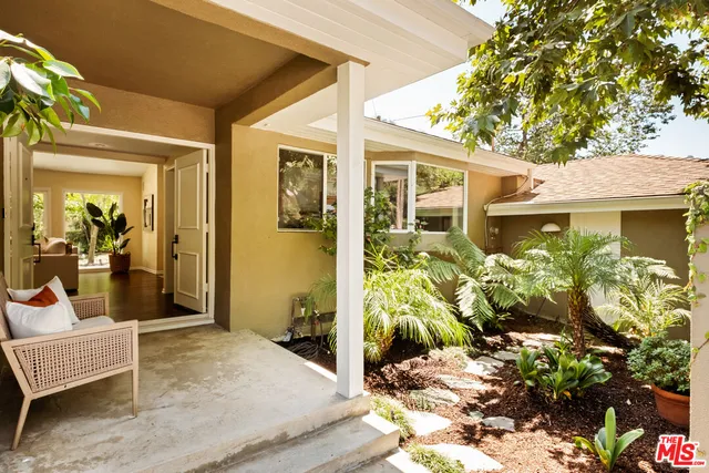 a view of a patio with table and chairs potted plants