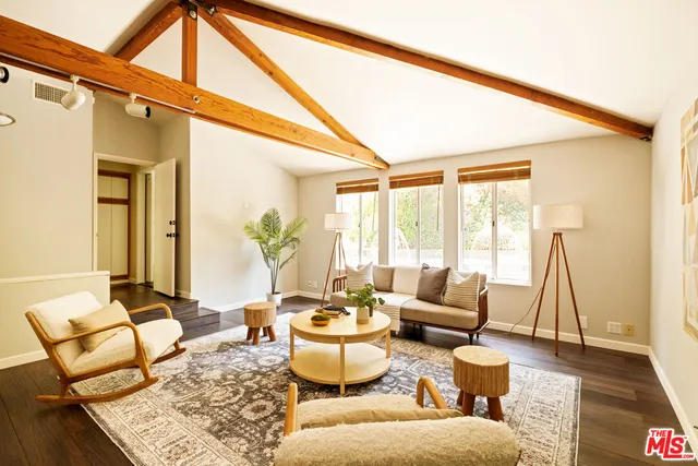 a living room with furniture and floor to ceiling windows