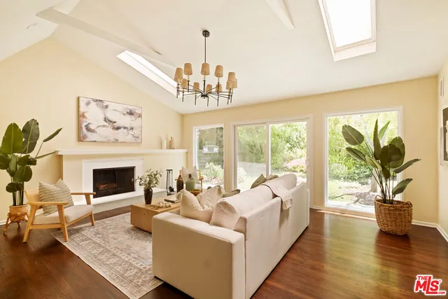 a living room with furniture a fireplace and a chandelier