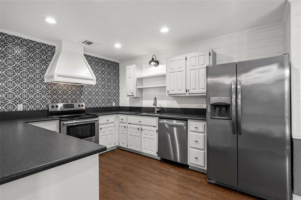 310 Ruth Drive Hewitt, TX 76643 - Photo 7 of 25 Kitchen featuring wood-finish flooring, white grey cabinetry, dark countertops, and stainless steel appliances, including a range, dishwasher, and side-by-side refrigerator