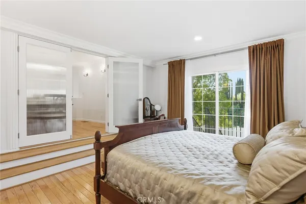 a bedroom with a bed and large windows