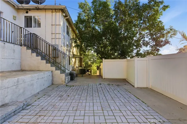 a view of a patio with table and chairs and wooden fence