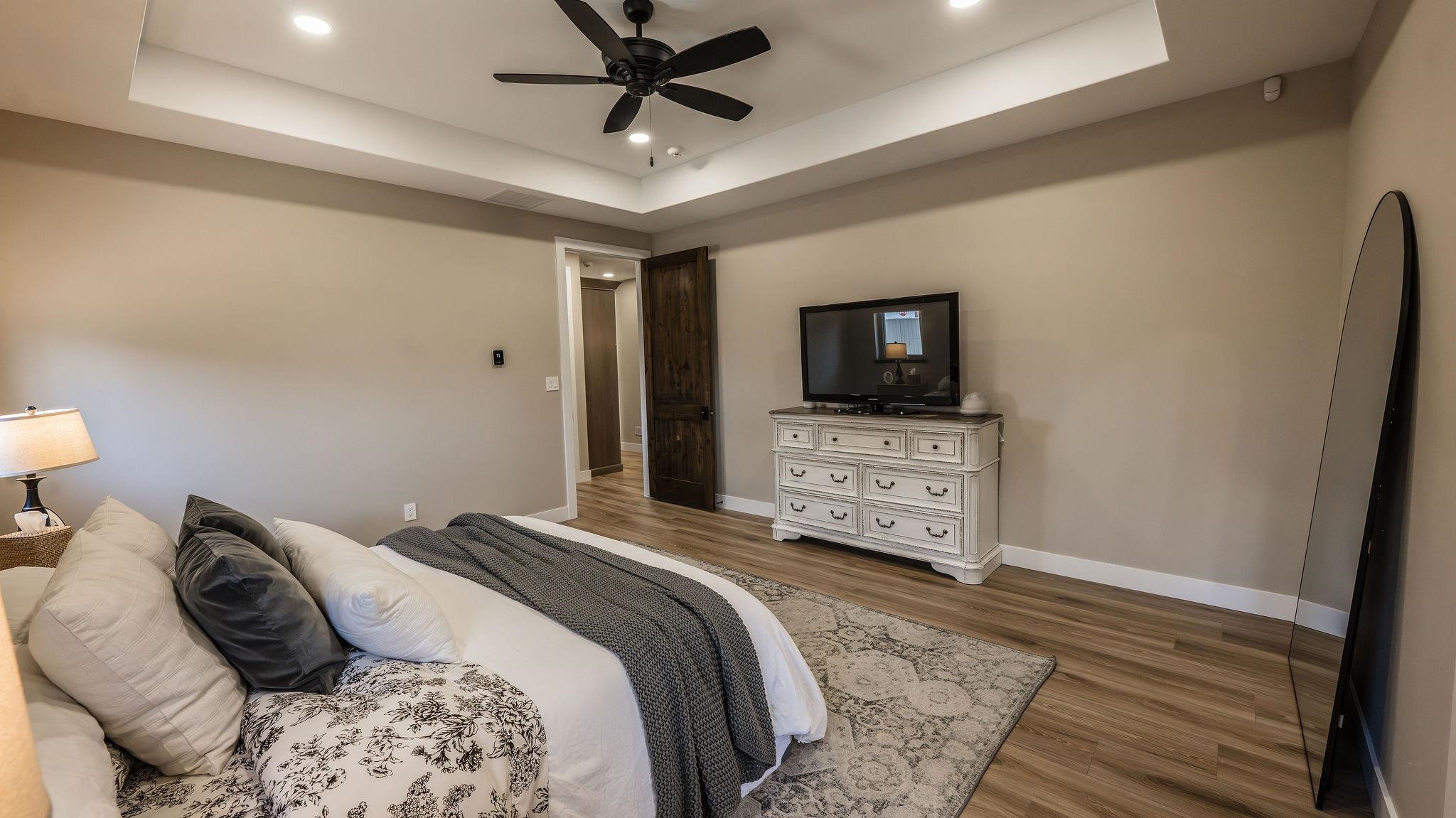 2639 Emerald Ridge Lane Grand Junction, CO 81506 - Photo 14 of 42 a bedroom with a bed a tv and wooden floor