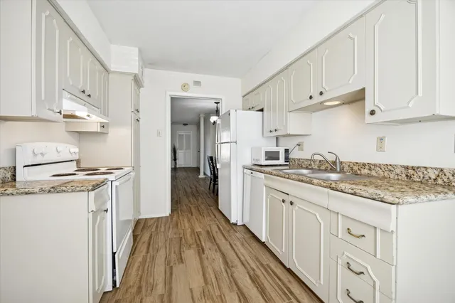 a kitchen with stainless steel appliances granite countertop a lot of counter space and wooden floors