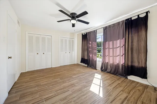 a view of a livingroom with a ceiling fan and wooden floor