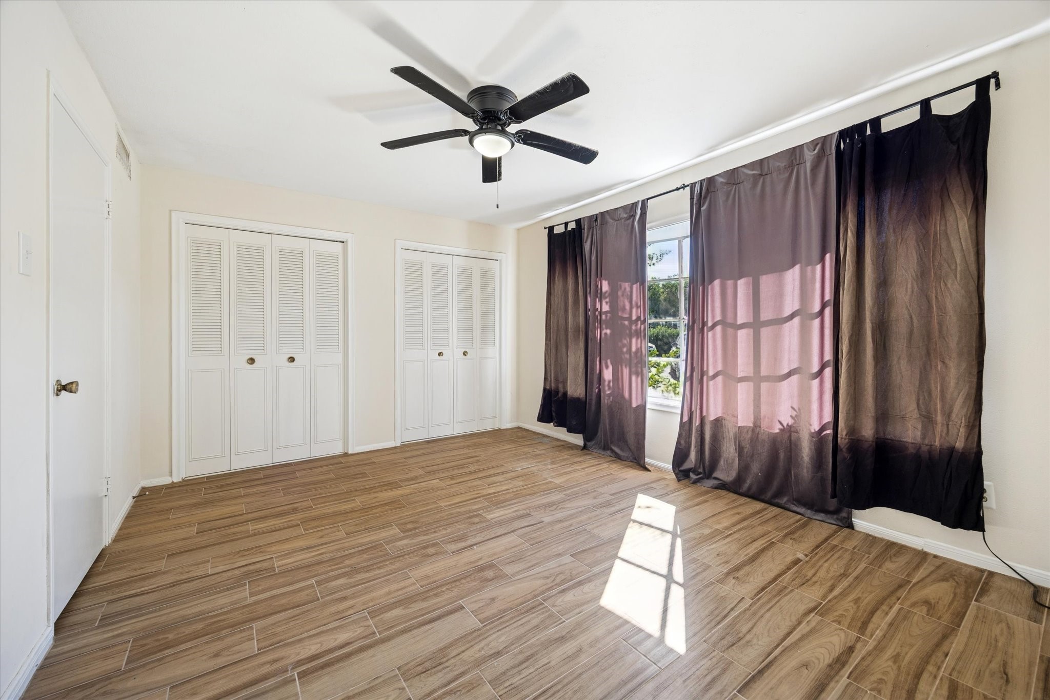 7600 Burgoyne Road, Unit 152 Houston, TX 77063 - Photo 6 of 16 a view of a livingroom with a ceiling fan and wooden floor