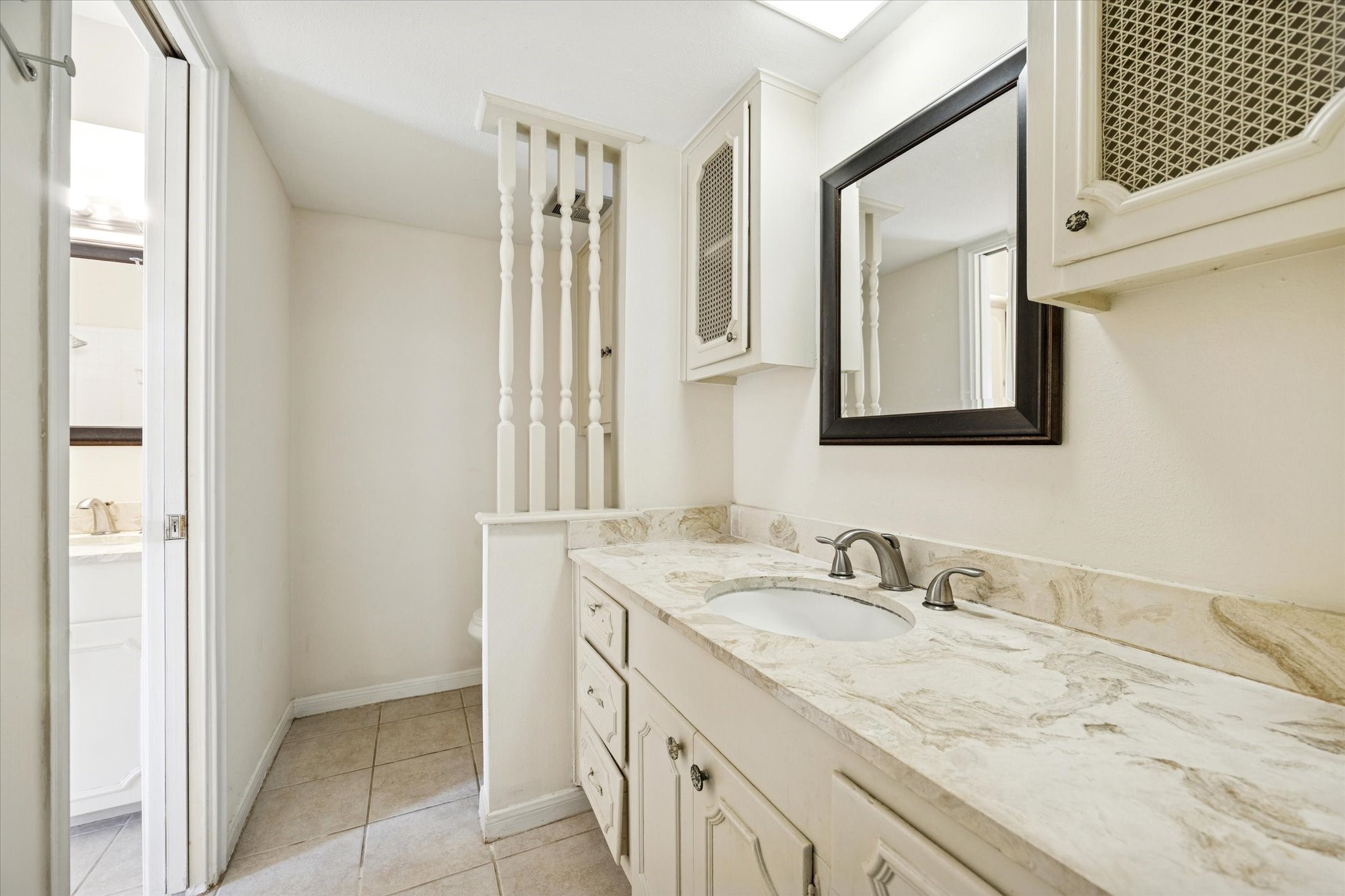 7600 Burgoyne Road, Unit 152 Houston, TX 77063 - Photo 10 of 16 a bathroom with a granite countertop sink and a mirror