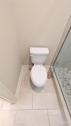 a white toilet sitting next to a shower