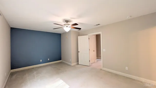 a view of an empty room with a chandelier fan