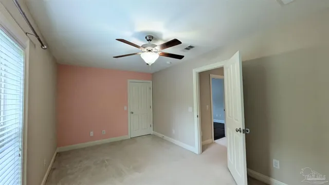 an empty room with a ceiling fan and a window