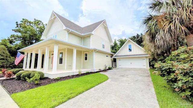 a view of a house with a small yard and potted plants