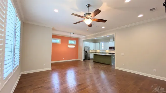 a view of an empty room with window and wooden floor