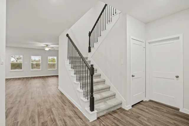 a view of a hallway with wooden floor and entryway