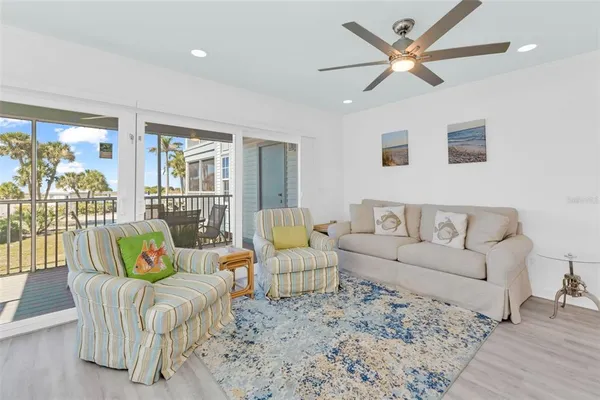 a kitchen with stainless steel appliances kitchen island granite countertop a refrigerator a stove a sink and white cabinets with wooden floor