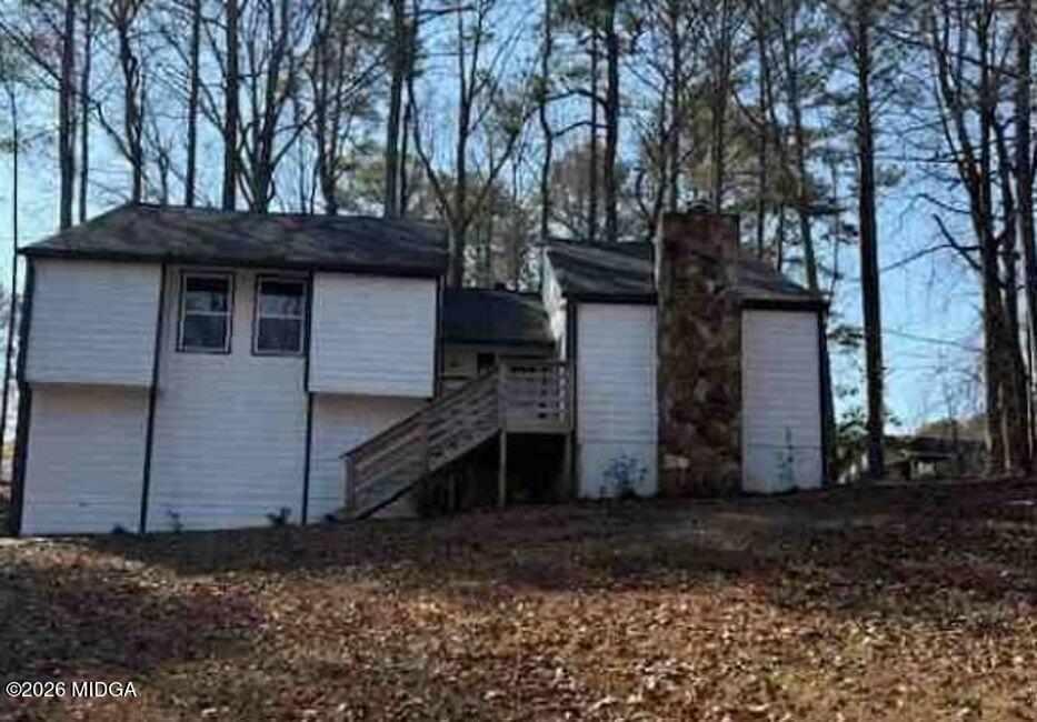 a house is sitting in middle of forest