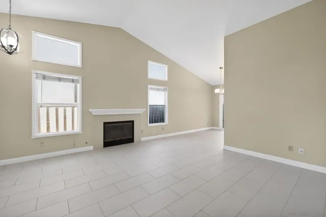 an empty room with windows and fireplace