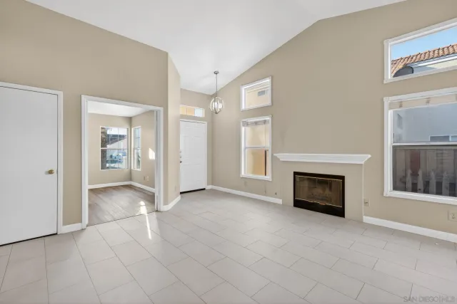 an empty room with fireplace and windows
