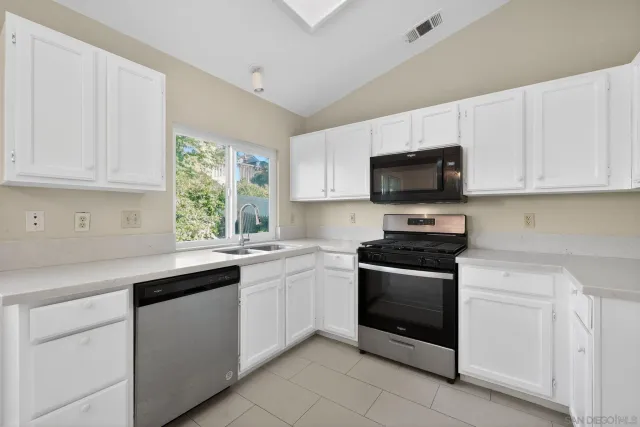 a kitchen with granite countertop white cabinets and white appliances