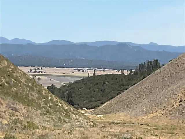 a view of a field with mountains in the background