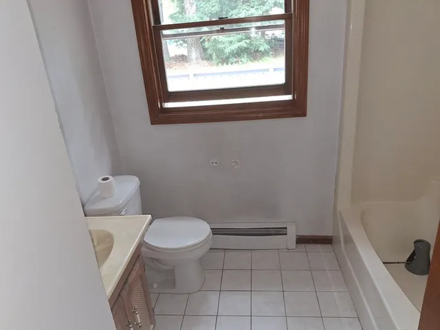 a white toilet sitting next to a window