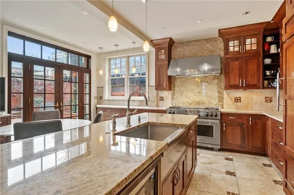 a kitchen with stainless steel appliances granite countertop a sink stove and cabinets
