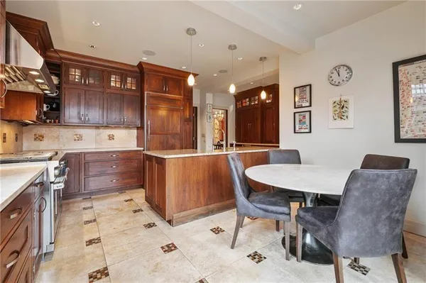 a kitchen with stainless steel appliances kitchen island granite countertop a table chairs in it and wooden floors