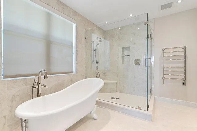 a bathroom with a tub shower sink and toilet