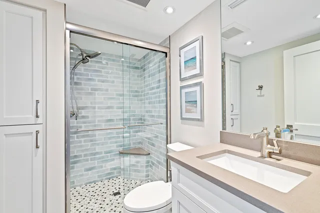 a bathroom with a sink toilet vanity and shower