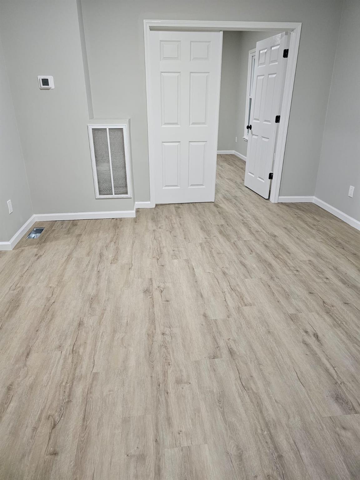 108 Pine Street, Unit #1 Wurtsboro, NY 12790 - Photo 12 of 18 an empty room with wooden floor and white walls