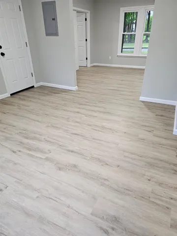a view of empty room with wooden floor
