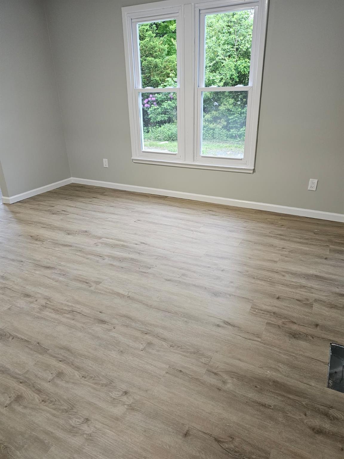 108 Pine Street, Unit #1 Wurtsboro, NY 12790 - Photo 8 of 18 an empty room with wooden floor and windows