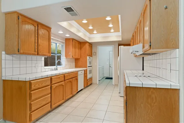 a kitchen with a sink a refrigerator and cabinets