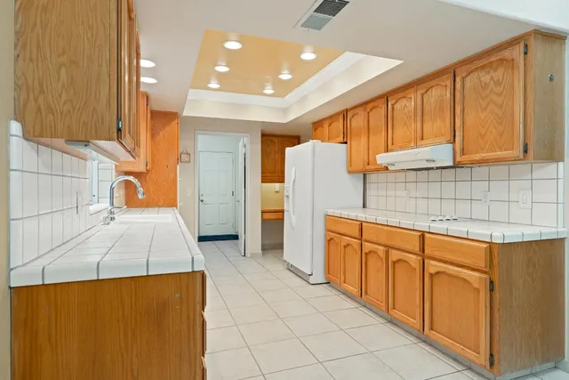 a kitchen that has a sink and a refrigerator in it
