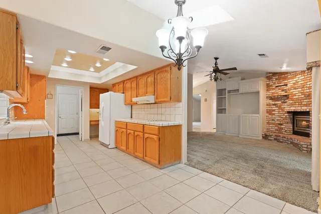 a large kitchen with stainless steel appliances kitchen island granite countertop a refrigerator and a stove top oven