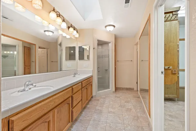 a spacious bathroom with a shower sink and mirror