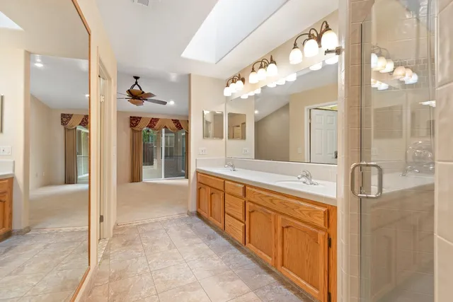 a spacious bathroom with a granite countertop sink mirror and bathtub