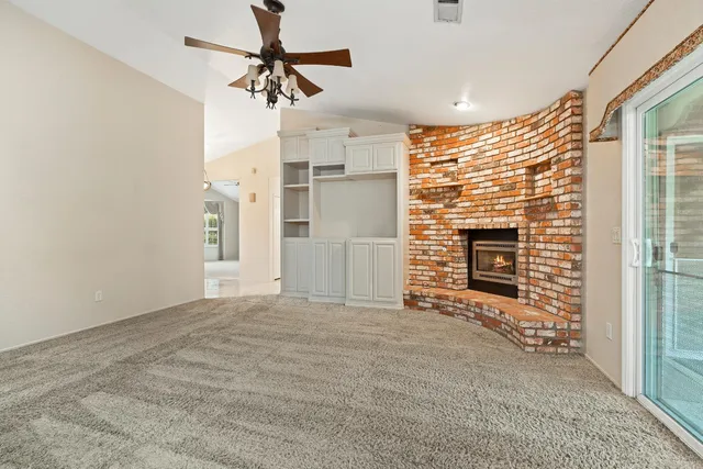 a view of empty room with fireplace and fan