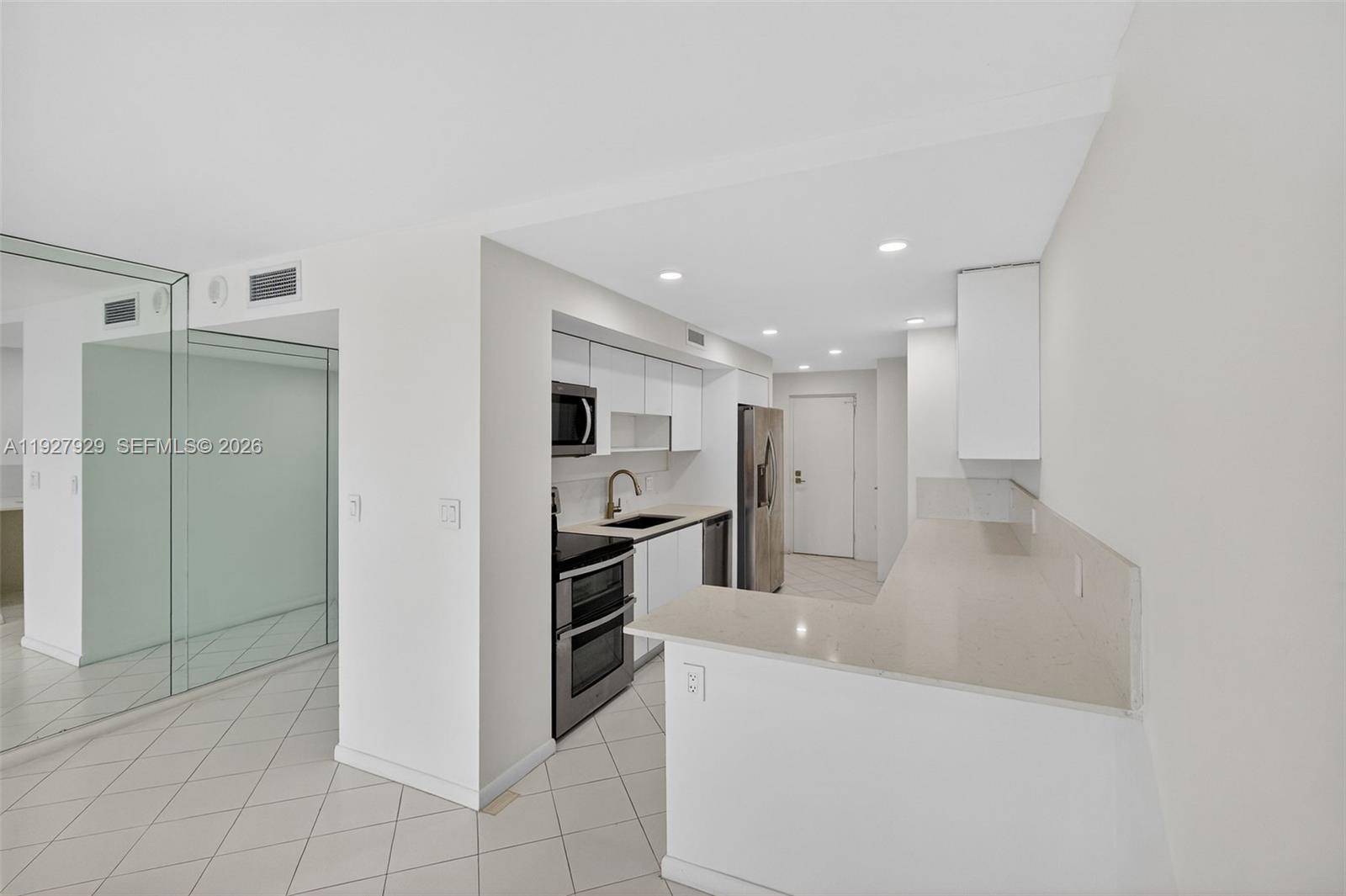 600 Grapetree Drive, Unit 8FS Key Biscayne, FL 33149 - Photo 11 of 54 a large kitchen with cabinets and stainless steel appliances