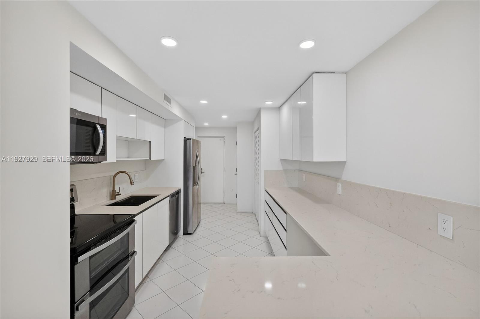 600 Grapetree Drive, Unit 8FS Key Biscayne, FL 33149 - Photo 12 of 54 a kitchen with granite countertop a sink and a stove top oven
