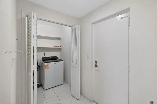 a kitchen with a refrigerator and white cabinets