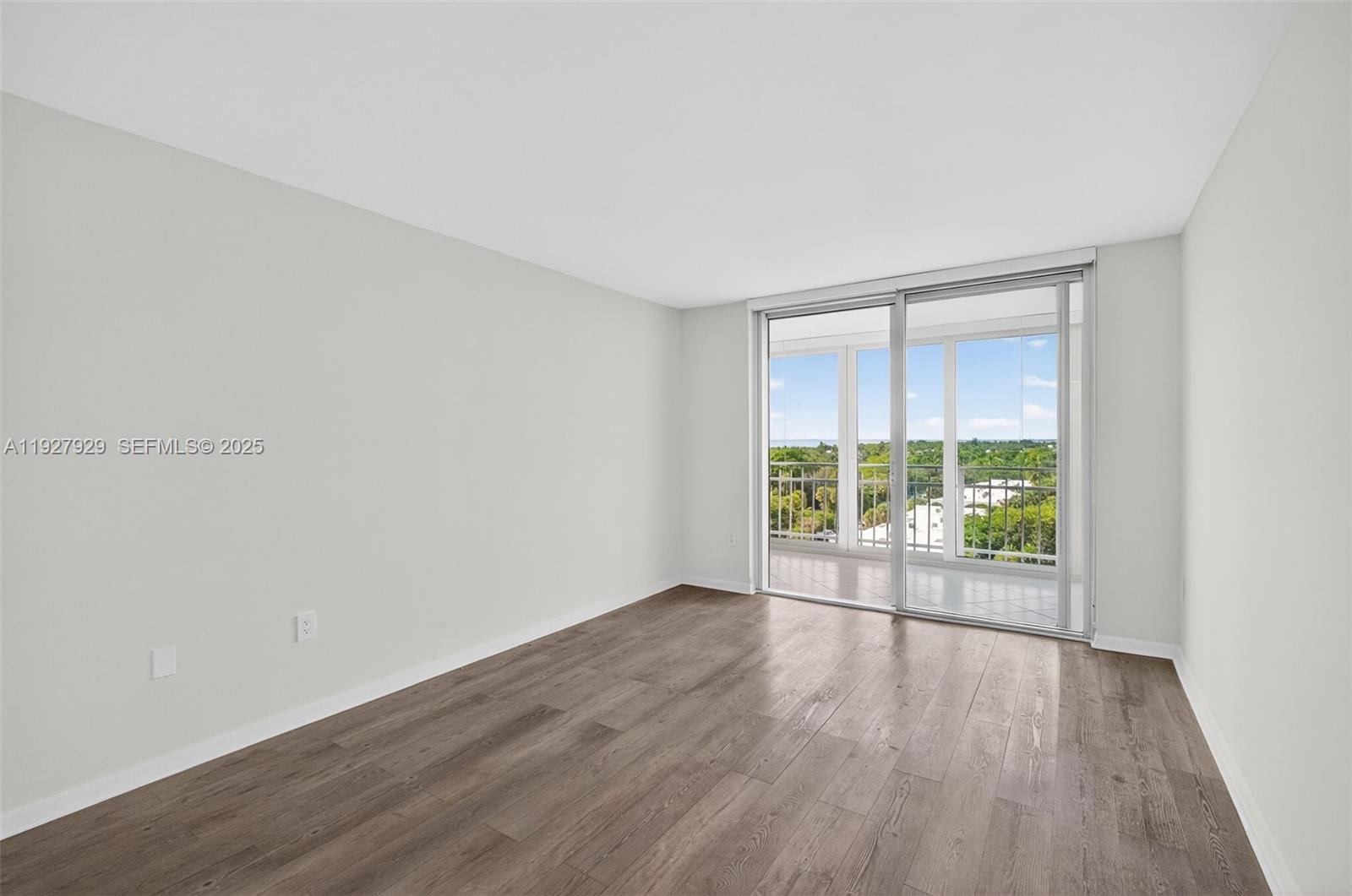 600 Grapetree Drive, Unit 8FS Key Biscayne, FL 33149 - Photo 23 of 54 an empty room with wooden floor and windows