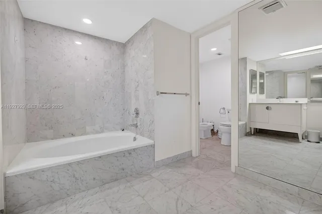 a bathroom with a tub sink and mirror