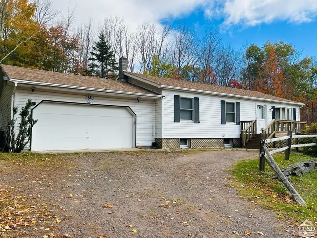 a view of a house with backyard and trees