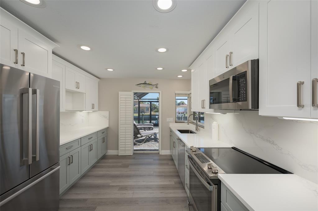 548 Gunwale Lane Longboat Key, FL 34228 - Photo 22 of 62 a kitchen with stainless steel appliances kitchen island granite countertop a refrigerator and a stove top oven