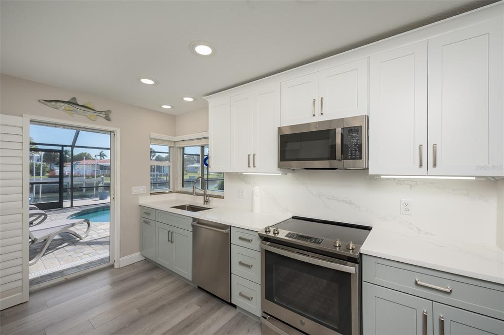 548 Gunwale Lane Longboat Key, FL 34228 - Photo 23 of 62 a kitchen with stainless steel appliances a stove microwave and sink