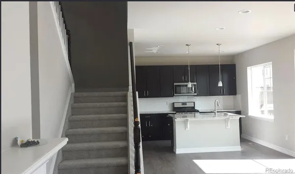 a kitchen with kitchen island white cabinets and stainless steel appliances