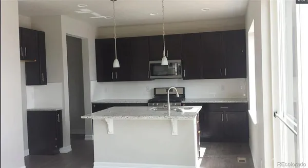 a bathroom with a sink a light fixture and a glass door